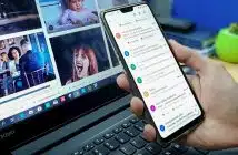 person using smartphone and laptop computer