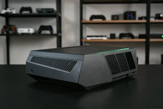 Console Xbox nouvelle génération posée sur un bureau noir minimaliste avec des accents LED verts, design angulaire en aluminium brossé